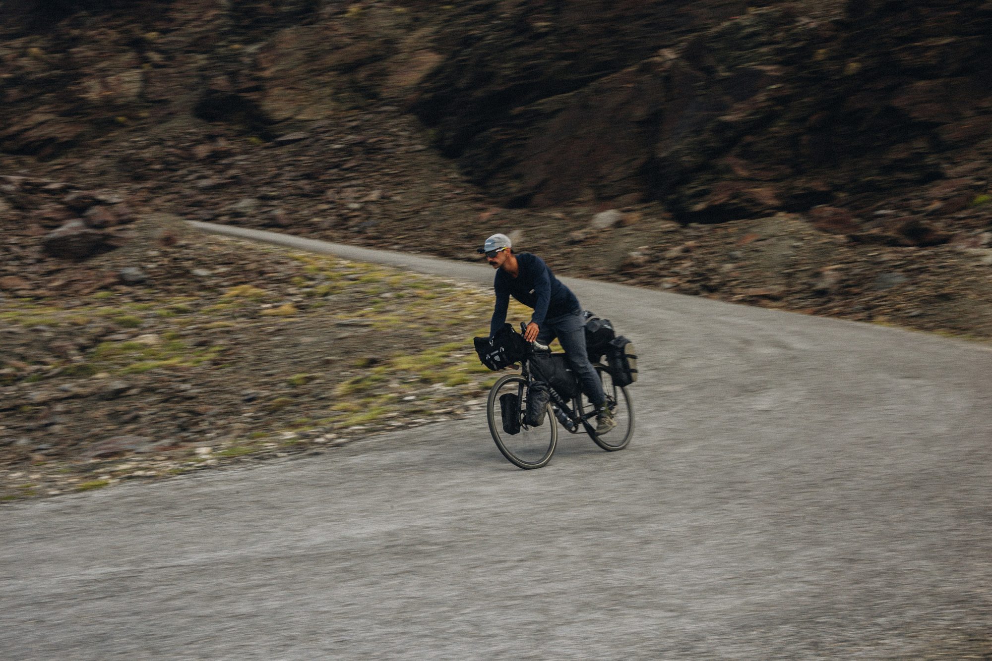 Loaded bikepacking rider on a mountain road